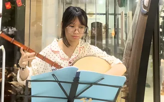 Học viên luyện đàn cùng bản nhạc