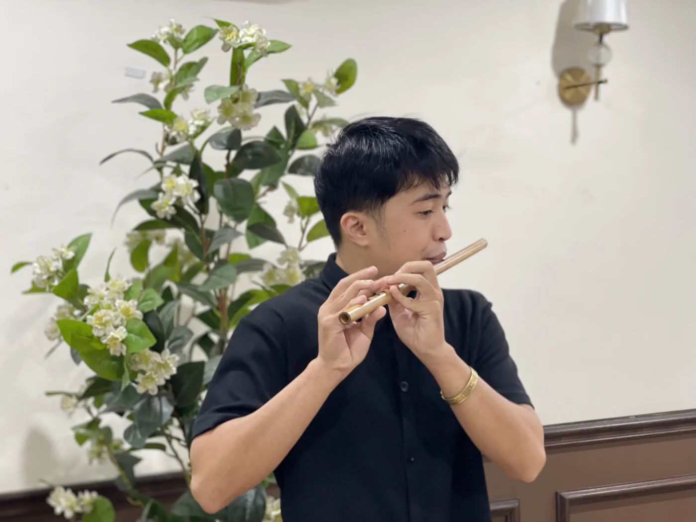 Thực hành sáo trúc trong không gian sáng, có cây xanh