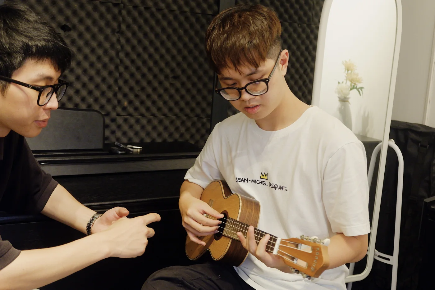 Giáo viên hướng dẫn học viên thực hành ukulele tại lớp
