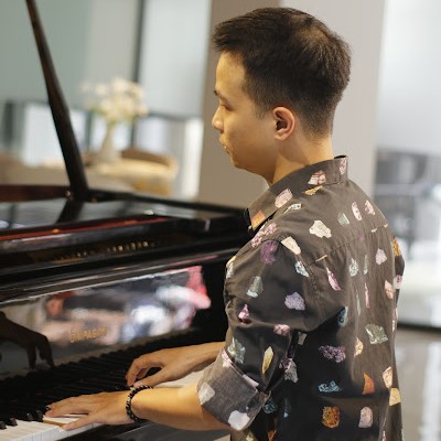 Người mặc áo sơ mi họa tiết chơi grand piano