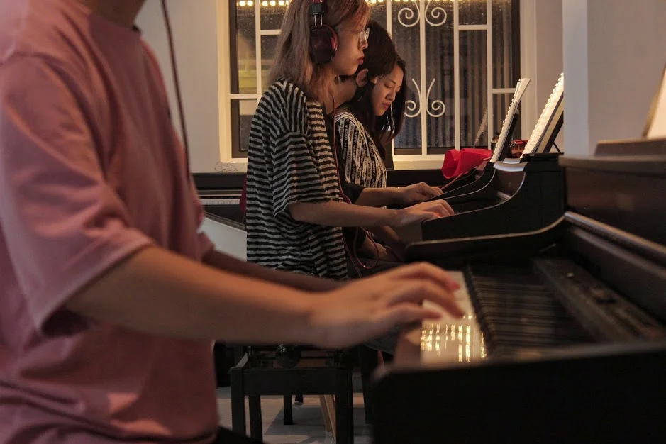 Hai người luyện tập Piano trong phòng học tại Piano Home
