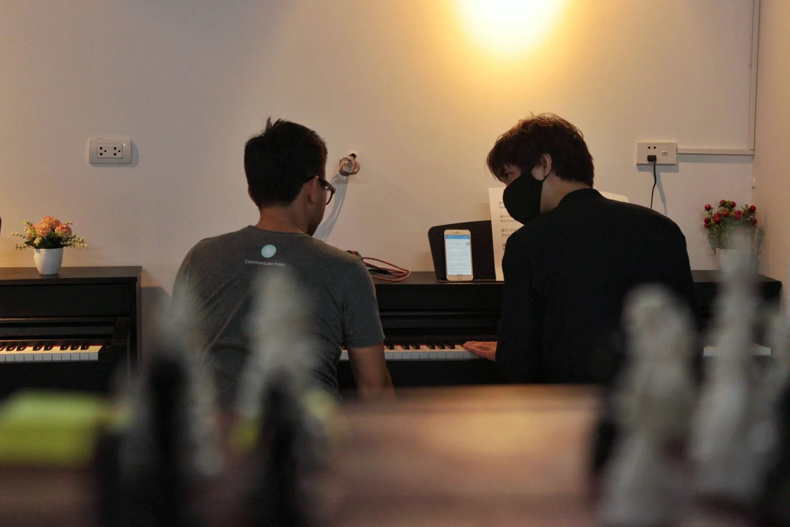 Hai người bên cây đàn Piano trong phòng học